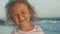 Facial portrait of beautiful little girl standing on the beach