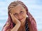 Facial portrait of pretty girl with pink African dreadlock, looking at camera with smile, brown eyes