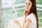 Facial skin care, young woman applies face cream in the spacious bathroom of a luxury hotel with panoramic park views