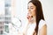 Facial skin care, young woman applies face cream in the spacious bathroom of a luxury hotel with panoramic park views