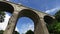 Facing upward perspective of driving under tall Cornwall Railway bridge in Newquay.