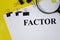 Factor word written on white paper and yellow background with magnifier. word