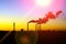 Factories smoke or steam into the atmosphere at sunset. concept of environmental pollution