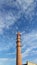 Factory chimney against a cloudy sky