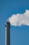 Factory chimney with smoke. Industrial pipe. Blue sky at sunny day. Air pollution/