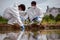 Factory scientists or biologists wear protective clothing while Collecting water samples in natural water sources near farmland.