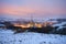 Factory in the snow covered landscape at dusk