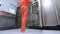 Factory worker in orange protective suit opening refrigerator storage