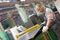 Factory worker removing metal burrs from steel sheet