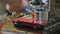 Factory worker washing lubricant from metal parts with stream of water