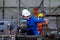 Factory worker woman or technician look to part of the machine and inspect the function while her co-worker work with other