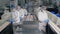 Factory workers pack products into plastic containers in a facility.