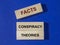 Facts against conspiracy theories inscription on wooden blocks on blue. Government fake ideas