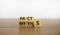 Facts or myths symbol. Turned cubes and changed the word `myths` to `facts`. Beautiful wooden table, white background, copy sp