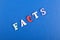 FACTS word on blue background composed from colorful abc alphabet block wooden letters, copy space for ad text. Learning