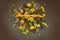 Faded bouquet of roses on a black background. Top view of dried blue and yellow flowers. Dry autumn roses in a wicker basket.