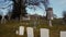 Faded headstones in a cemetery in East Hampton with an old, wooden windmill