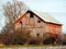 Faded red vintage hay barn with lightening rods on roof