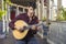 Fado musician playing on portuguese guitar under pergola in Lisbon, Portugal