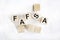 Fafsa word on wooden blocks and white table .Free Appication for Federal Student Aid Business concept
