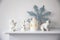 Faience figurines of angels with stars and wings, a decorative lantern and a figurine of a polar bear on a white console near the