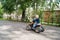 A fair-haired boy of three years in a leisure park rides along a track on a children`s orange electro-quad