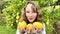 a fair-haired girl juggles lemons against the backdrop of a lemon tree in a tropical country, she is dressed in a white