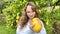 a fair-haired girl juggles lemons against the backdrop of a lemon tree in a tropical country, she is dressed in a white