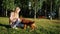 Fair haired girl smiles and plays with Russian spaniel dog