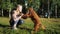 Fair haired girl smiles and plays with Russian spaniel dog