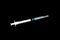 Fairly standard design single use syringe isolated over black background