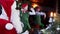 Fairy elves and Santa Claus at Christmas. Joyful friends elf and Santa with white beard making photos with retro camera.