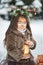 Fairy tale girl. Portrait a little girl in a deer dress with a painted face in the winter forest. Big brown antler