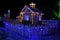 Fairy-tale house in the lights and a luminous window with a Christmas tree . Night photo.