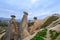 Fairytale landscape with unusual mountain formations. Three Sisters Rocks in Turkish Cappadocia. Group of tourists on