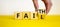 Faith instead fail symbol. Businessman turns a wooden cube and changes the word fail to faith. Beautiful yellow table, white