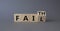 Faith vs Fail symbol. Turned wooden cube with words Fail and Faith. Beautiful grey background. Business and Faith vs Fail concept