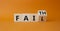 Faith vs Fail symbol. Turned wooden cube with words Fail and Faith. Beautiful orange background. Business and Faith vs Fail