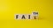 Faith vs Fail symbol. Turned wooden cube with words Fail and Faith. Beautiful yellow background. Business and Faith vs Fail