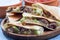 Fajita quesadilla with pieces of beef steak, green bell pepper, onion and cheese, on a wooden plate