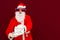 Fake Bearded man in Santa Claus hat holds gift letter envelope box.Christmas gift. Christmas,New Year holidays