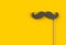 Fake black mustache on yellow background