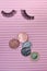 Fake lashes and pounds coins on pink background, price concept