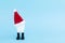 Fake toy tooth in santa claus hat on blue background. creative dental teeth, tool.