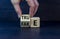 Fake or true symbol. Businessman flips a wooden cube and changes the word `fake` to `true` or vice versa. Beautiful grey