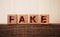 Fake word letters on wooden blocks, over dark oak table. True and lies in businiess and news concept