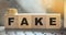 FAKE word written in wooden blocks on computer keyboard