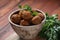 Falafel balls with parsley in wooden bowl with tahini sauce.