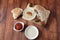 Falafel in pita bread with vegetable salad, harissa sauce, humus, tahini on wooden background.