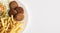 Falafel plate with chips and salad on white background with space for text